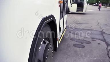 在灰色沥青背景下，白色<strong>巴士</strong>和<strong>巴士</strong>轮停车的侧面视图。 场景。 关闭白色客车